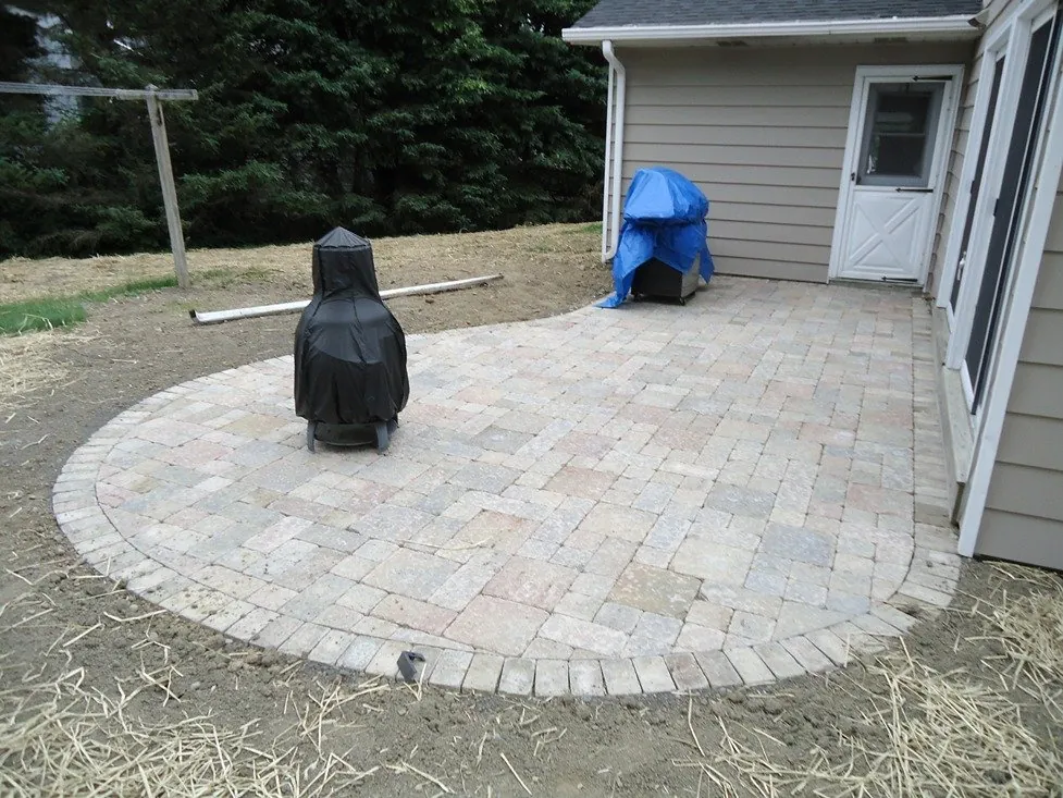 Round paver patio installed behind a home