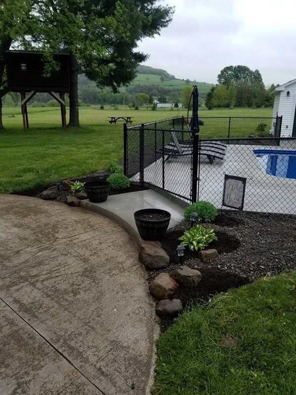 Shrubs and perennials planted along a curved concrete patio